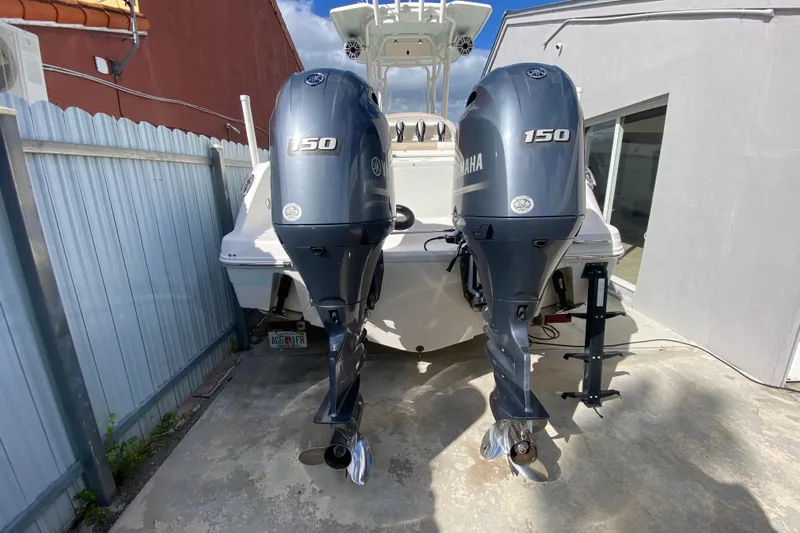  Yacht Photos Pics 2018 Robalo R242 Center Console with twin Yamaha 150 engines in a driveway.