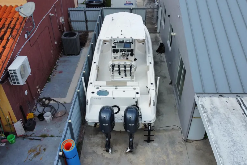  Yacht Photos Pics 2018 Robalo R242 Center Console boat parked in a narrow driveway with twin engines.