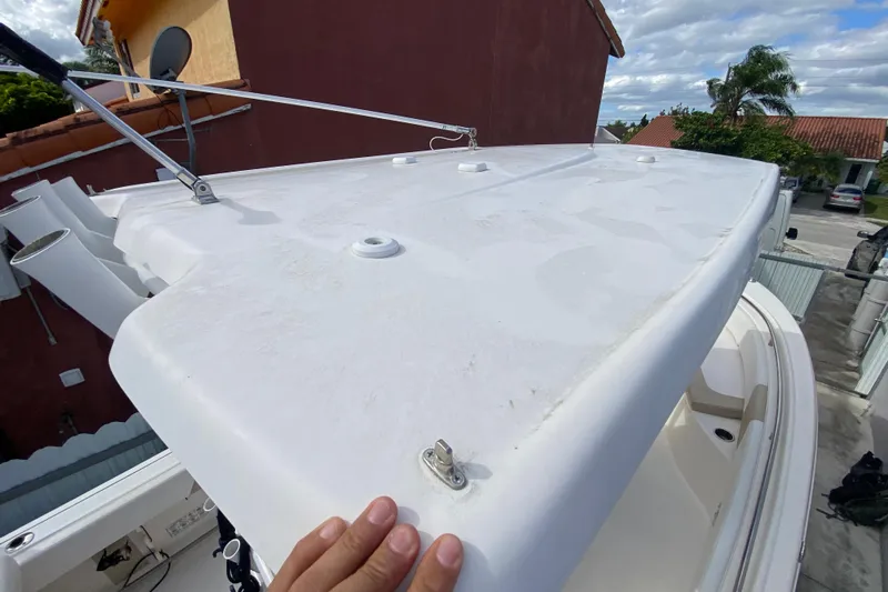  Yacht Photos Pics 2018 Robalo R242 Center Console boat deck with hand touching white surface.