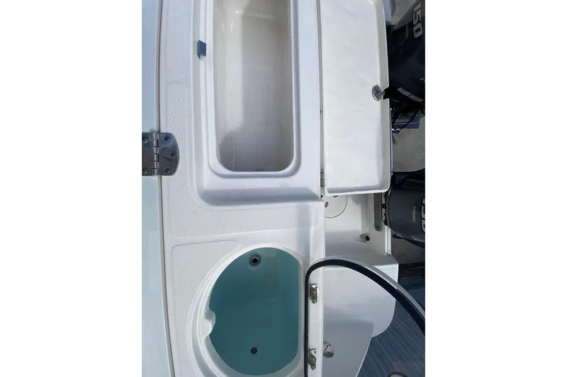  Yacht Photos Pics 2018 Robalo R242 Center Console boat with open storage compartments and visible engine.