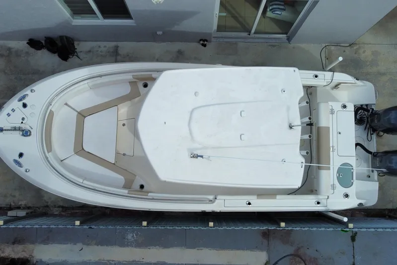  Yacht Photos Pics Overhead view of a 2018 Robalo R242 Center Console boat docked beside a building.