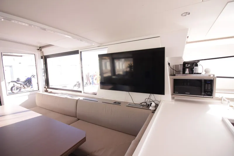 Amura Yacht Photos Pics Modern interior of a 2021 Bali 5.4 yacht with TV, sofa, and kitchenette.