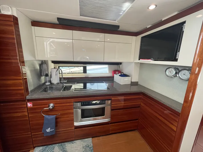 Ohana Yacht Photos Pics Luxurious 2013 Sealine S450 yacht kitchen with modern appliances and sleek wood cabinetry.