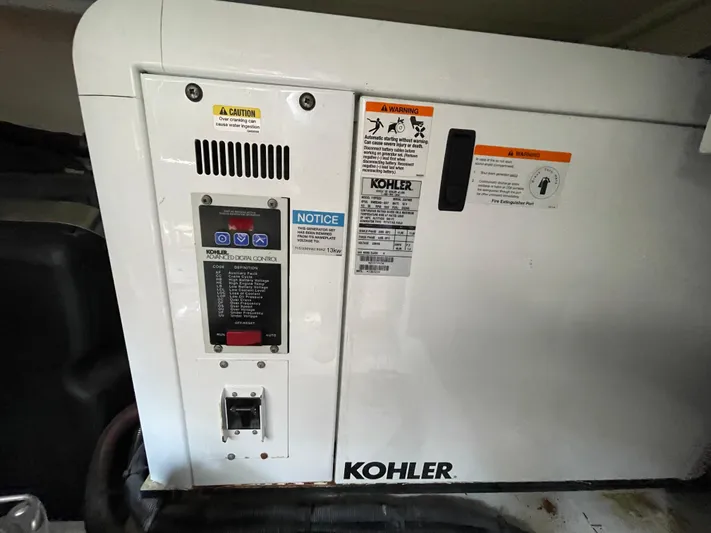 Ohana Yacht Photos Pics Kohler generator in a 2013 Sealine S450 yacht engine room, featuring control panel and safety warnings.