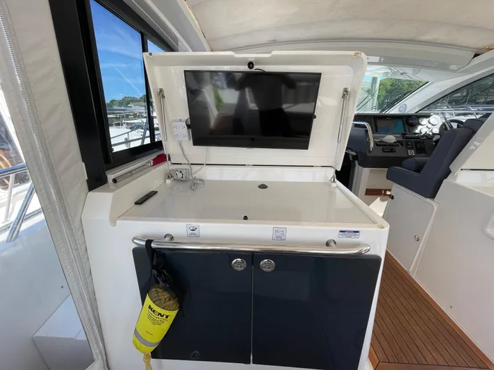 Ohana Yacht Photos Pics 2013 Sealine S450 yacht interior with TV, control panel, and seating area.