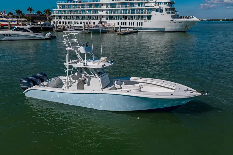 Rock N Reel Yacht Photos Pics 2018 Yellowfin 36 Offshore boat docked, featuring triple outboard engines, with a large ship in the background.
