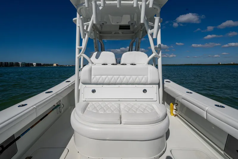 Rock N Reel Yacht Photos Pics 2018 Yellowfin 36 Offshore boat interior with white seating, on calm water under blue sky.