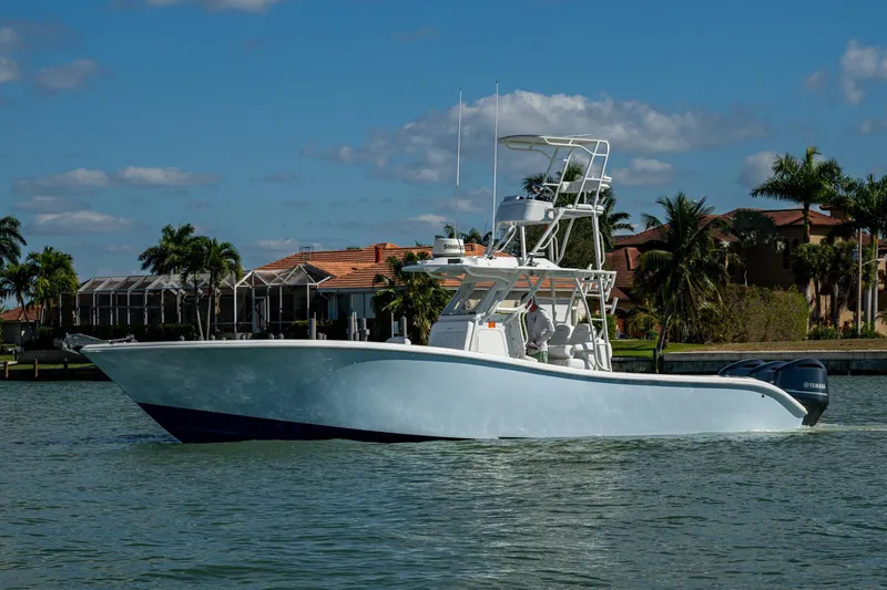 Rock N Reel Yacht Photos Pics 2018 Yellowfin 36 Offshore boat cruising on a sunny day near waterfront homes.