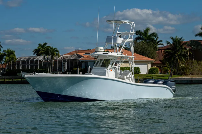 Rock N Reel Yacht Photos Pics 2018 Yellowfin 36 Offshore boat cruising on a sunny day near waterfront homes.