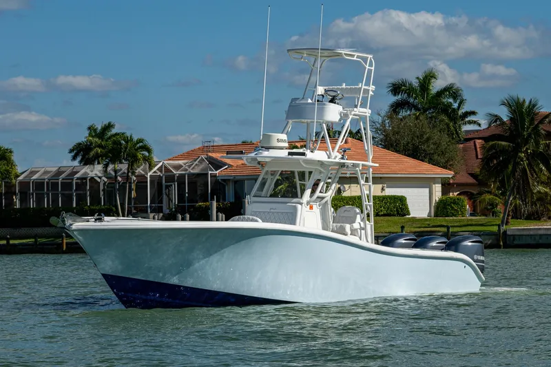 Rock N Reel Yacht Photos Pics 2018 Yellowfin 36 Offshore boat cruising on a sunny day near waterfront homes.