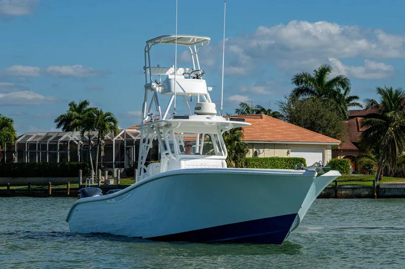 Rock N Reel Yacht Photos Pics 2018 Yellowfin 36 Offshore boat on water, with tropical background and clear sky.
