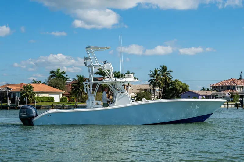 Rock N Reel Yacht Photos Pics 2018 Yellowfin 36 Offshore boat cruising on a sunny day near waterfront homes.