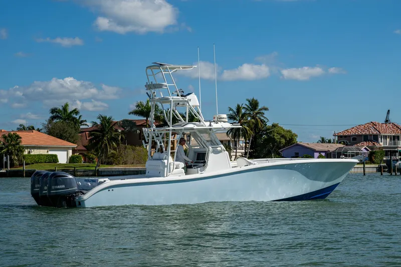 Rock N Reel Yacht Photos Pics 2018 Yellowfin 36 Offshore boat cruising on a sunny day near waterfront homes.