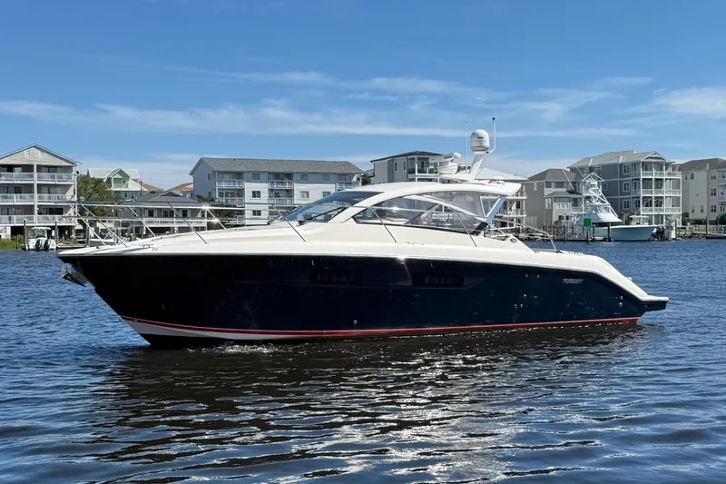  Yacht Photos Pics 2013 Pursuit SC 365i Sport Coupe yacht on calm water, with coastal buildings in background.