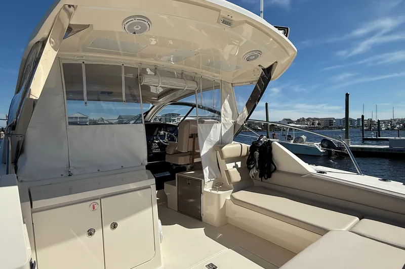  Yacht Photos Pics 2013 Pursuit SC 365i Sport Coupe interior with seating, docked at marina under clear sky.