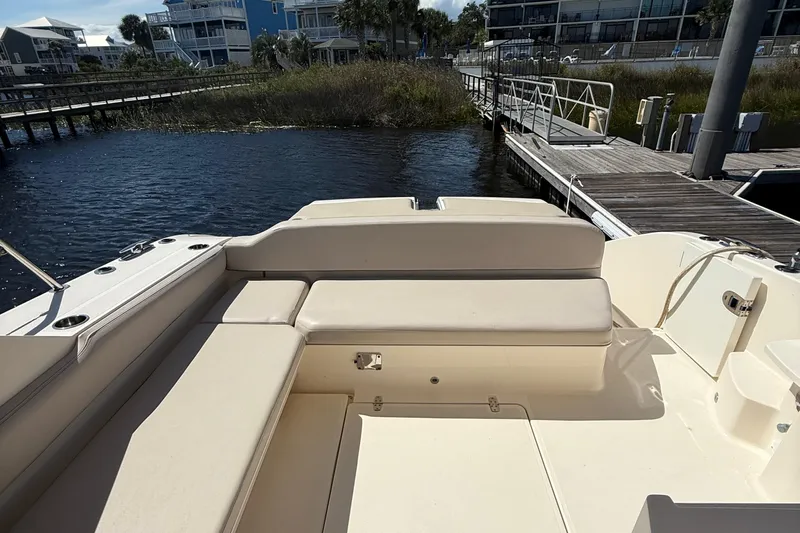  Yacht Photos Pics 2013 Pursuit SC 365i Sport Coupe boat interior with beige seating at a dock.