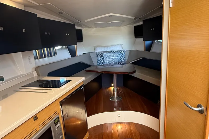  Yacht Photos Pics 2013 Pursuit SC 365i Sport Coupe interior with kitchenette and cozy seating area.