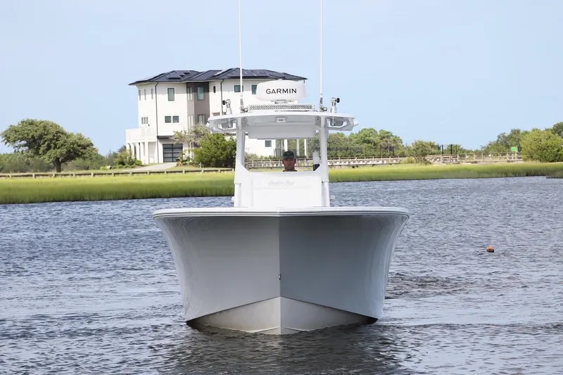  Yacht Photos Pics 2022 Onslow Bay 33 boat on water with modern house in background.