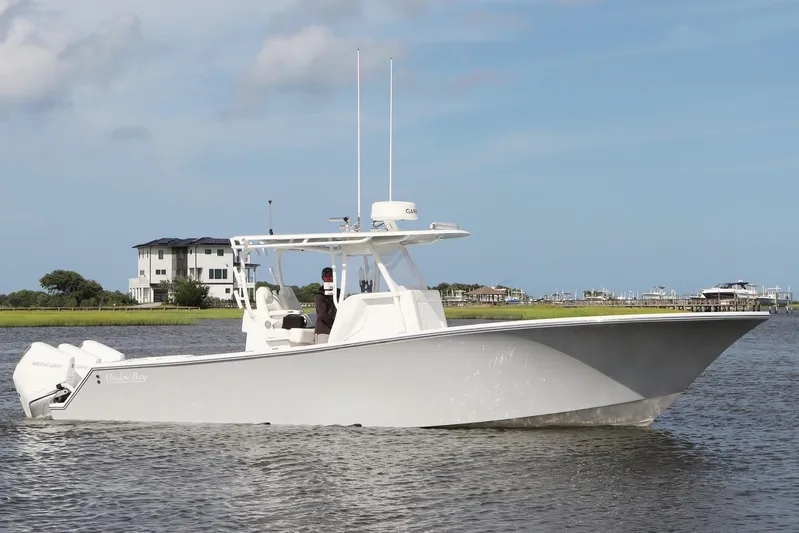  Yacht Photos Pics 2022 Onslow Bay 33 boat cruising on a calm waterway with houses in the background.