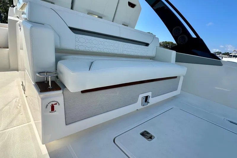  Yacht Photos Pics 2026 Tiara Yachts 34 LS boat interior with white seating and fire extinguisher compartment.