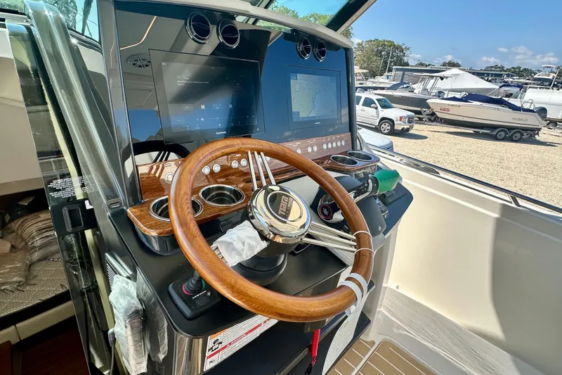  Yacht Photos Pics 2026 Tiara Yachts 34 LS helm with wooden steering wheel and modern navigation displays.