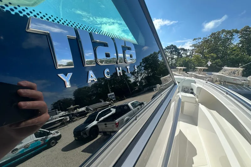  Yacht Photos Pics 2026 Tiara Yachts 34 LS, sleek design with reflective logo, sunny outdoor setting.