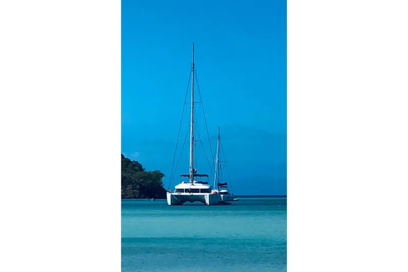 Somni Yacht Photos Pics 2013 Lagoon 560 S2 catamaran anchored in clear blue tropical waters.