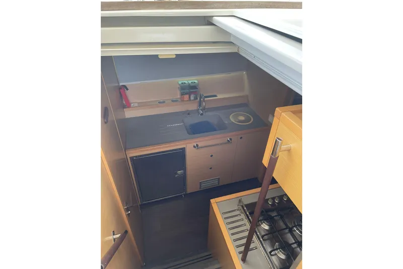 Somni Yacht Photos Pics Compact kitchen in 2013 Lagoon 560 S2 yacht with modern amenities and wooden cabinetry.