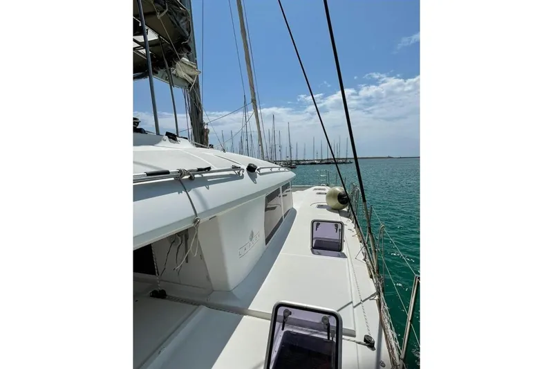 Somni Yacht Photos Pics 2013 Lagoon 560 S2 catamaran on calm sea under clear blue sky.