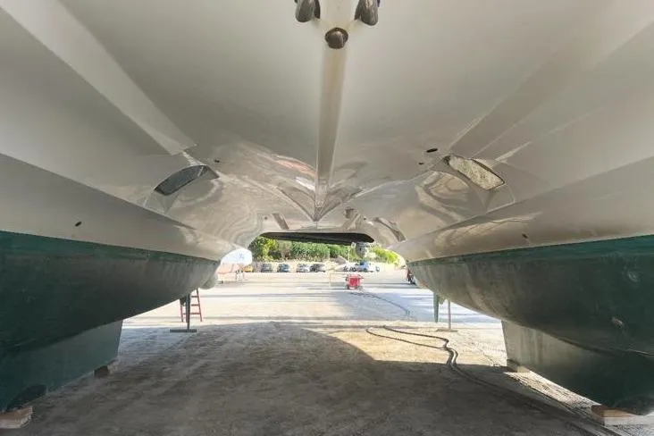 Somni Yacht Photos Pics Underneath view of a 2013 Lagoon 560 S2 catamaran on dry dock.