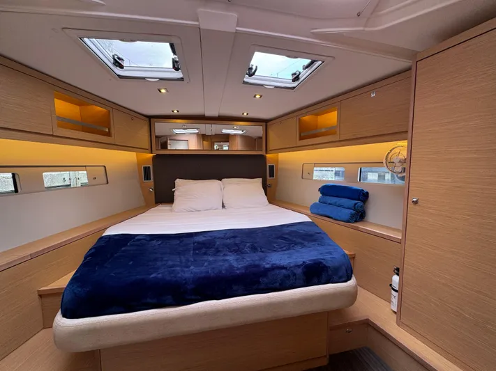 Pura Vida Yacht Photos Pics Luxurious cabin interior of 2022 Dufour 530 yacht with cozy bed and modern wood finish.
