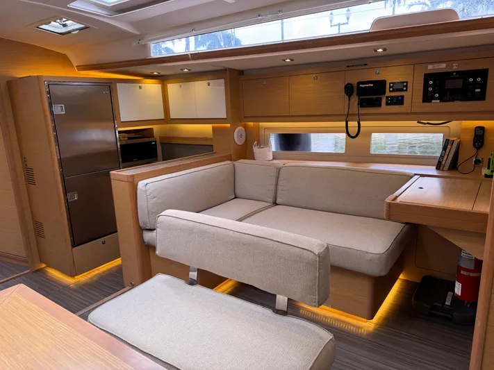 Pura Vida Yacht Photos Pics Luxurious interior of 2022 Dufour 530 yacht with modern seating and sleek kitchen area.