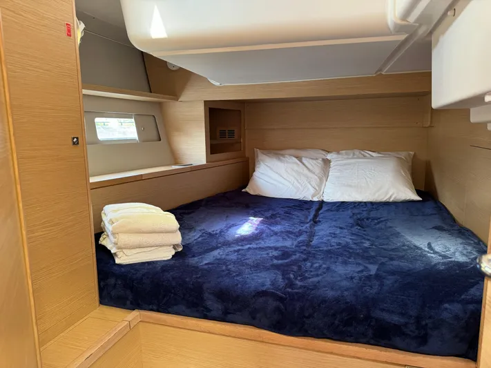 Pura Vida Yacht Photos Pics Cozy cabin interior of 2022 Dufour 530 yacht with plush bedding and natural wood finish.