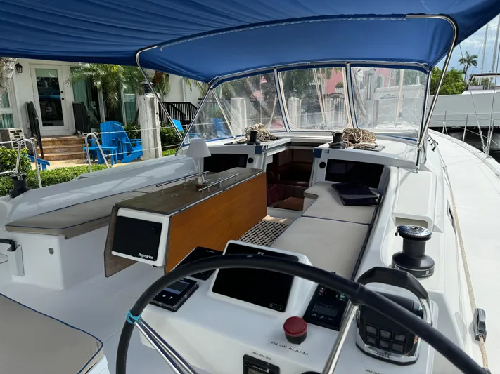 Pura Vida Yacht Photos Pics 2022 Dufour 530 yacht cockpit with blue canopy, modern controls, and comfortable seating.