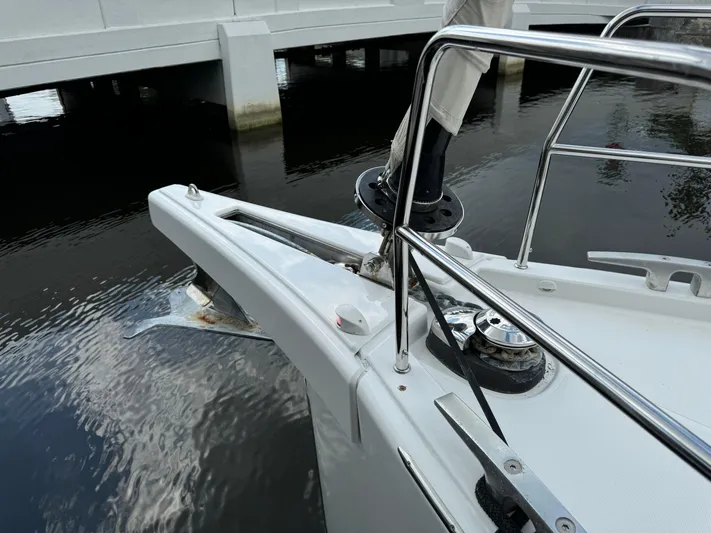 Pura Vida Yacht Photos Pics Bow of 2022 Dufour 530 yacht with anchor and railing, near a bridge.