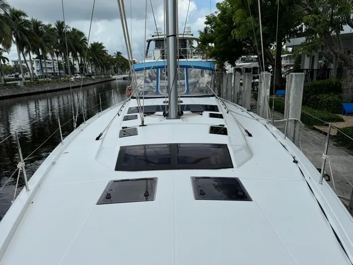 Pura Vida Yacht Photos Pics 2022 Dufour 530 yacht docked by a canal with palm trees.