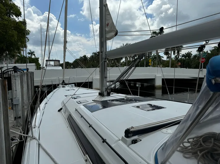 Pura Vida Yacht Photos Pics 2022 Dufour 530 sailboat docked near a bridge under a partly cloudy sky.