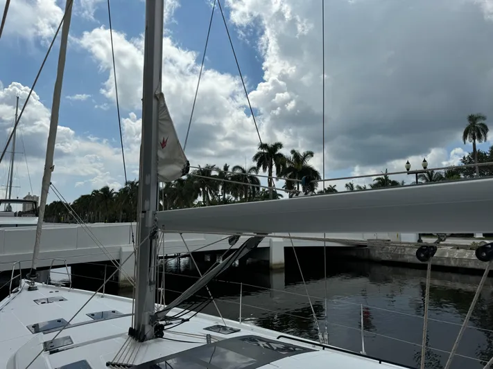 Pura Vida Yacht Photos Pics Sailing yacht Dufour 530, 2022 model, docked under cloudy sky with palm trees.