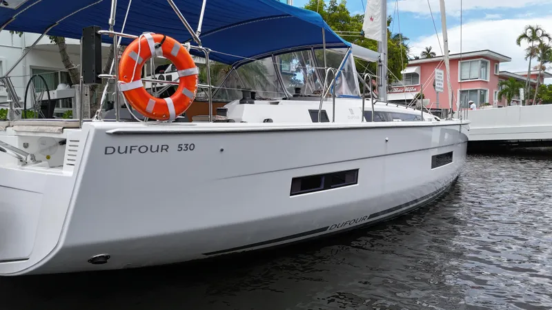 Pura Vida Yacht Photos Pics 2022 Dufour 530 yacht docked, featuring sleek design and blue canopy.