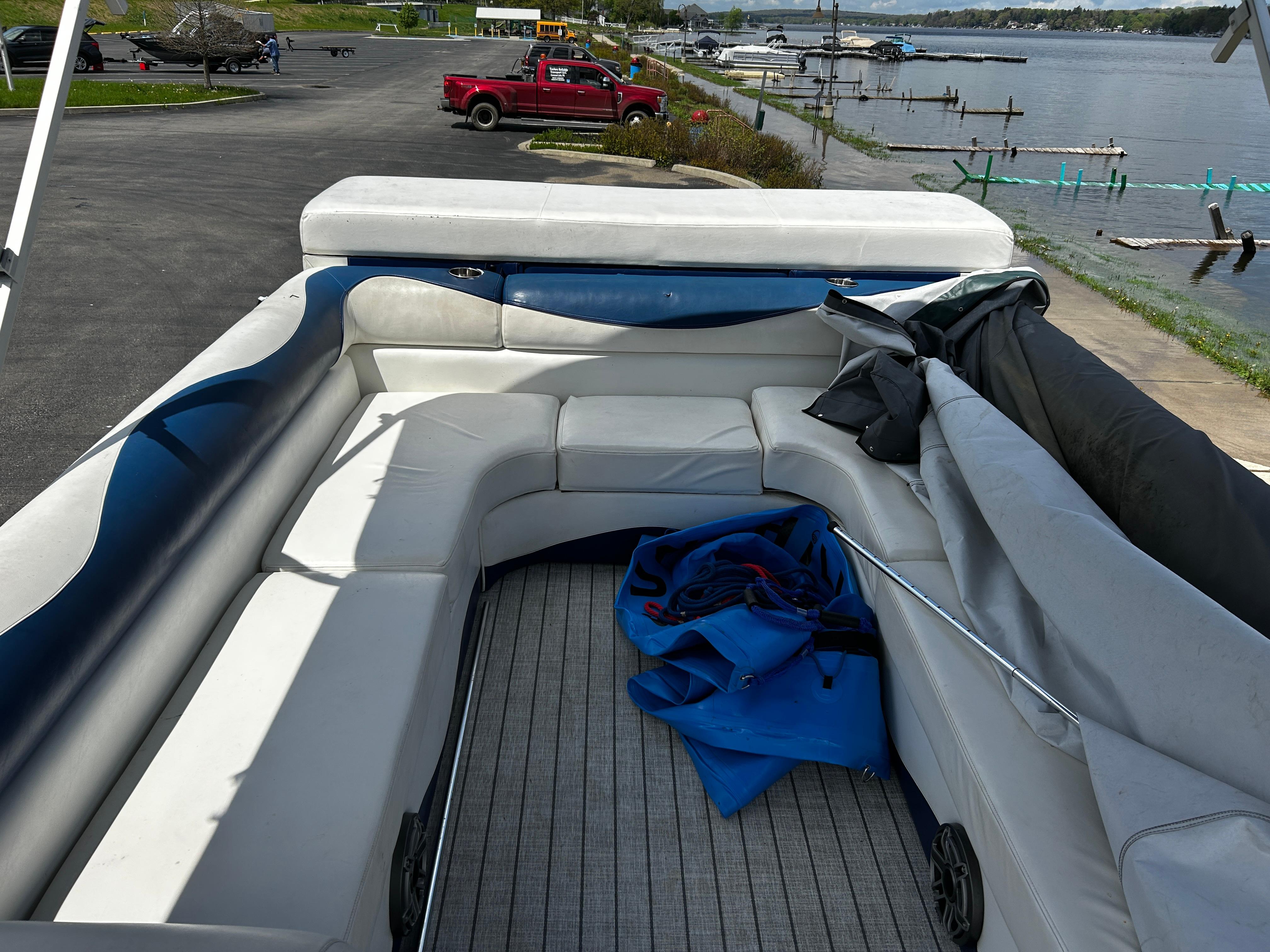 2005 Evolution 26 boat with spacious seating, docked by a scenic lakeside.