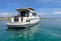 Nimbus 365 yacht from 2018 on clear blue water, with scenic coastal backdrop.