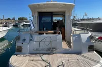 2018 Nimbus 365 yacht docked at marina, rear view with open cabin door.