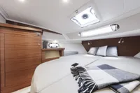 Luxurious cabin interior of 2018 Nimbus 365 yacht with cozy bedding and modern wood finish.