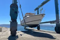 2018 Nimbus 365 boat being lifted by a crane near the sea.