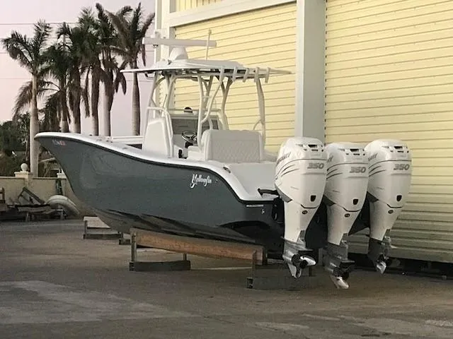  Yacht Photos Pics 2019 Yellowfin 34 Offshore boat with triple engines, docked near palm trees.