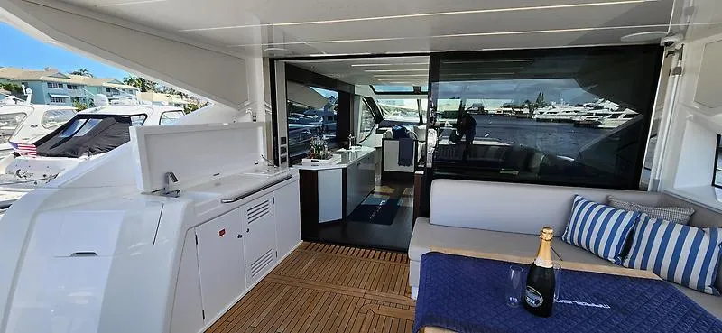  Yacht Photos Pics Luxurious Sunseeker Predator 74 XPS yacht deck with seating, champagne, and marina view.