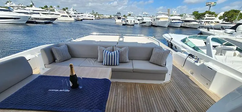  Yacht Photos Pics Luxury Sunseeker Predator 74 XPS yacht deck with seating, table, and champagne, docked at marina.