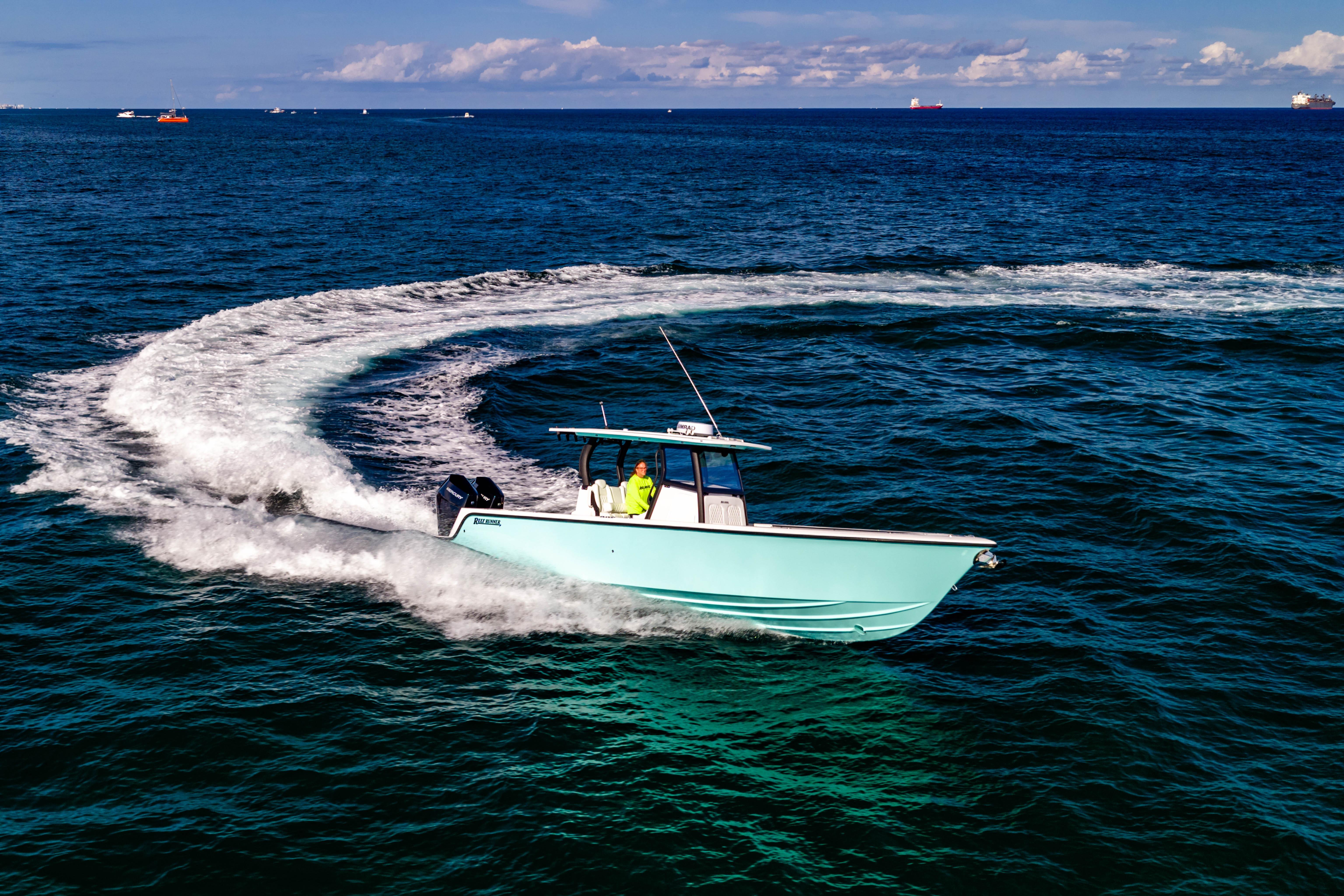 2026 Reef Runner 340 boat making a sharp turn on open ocean waters.