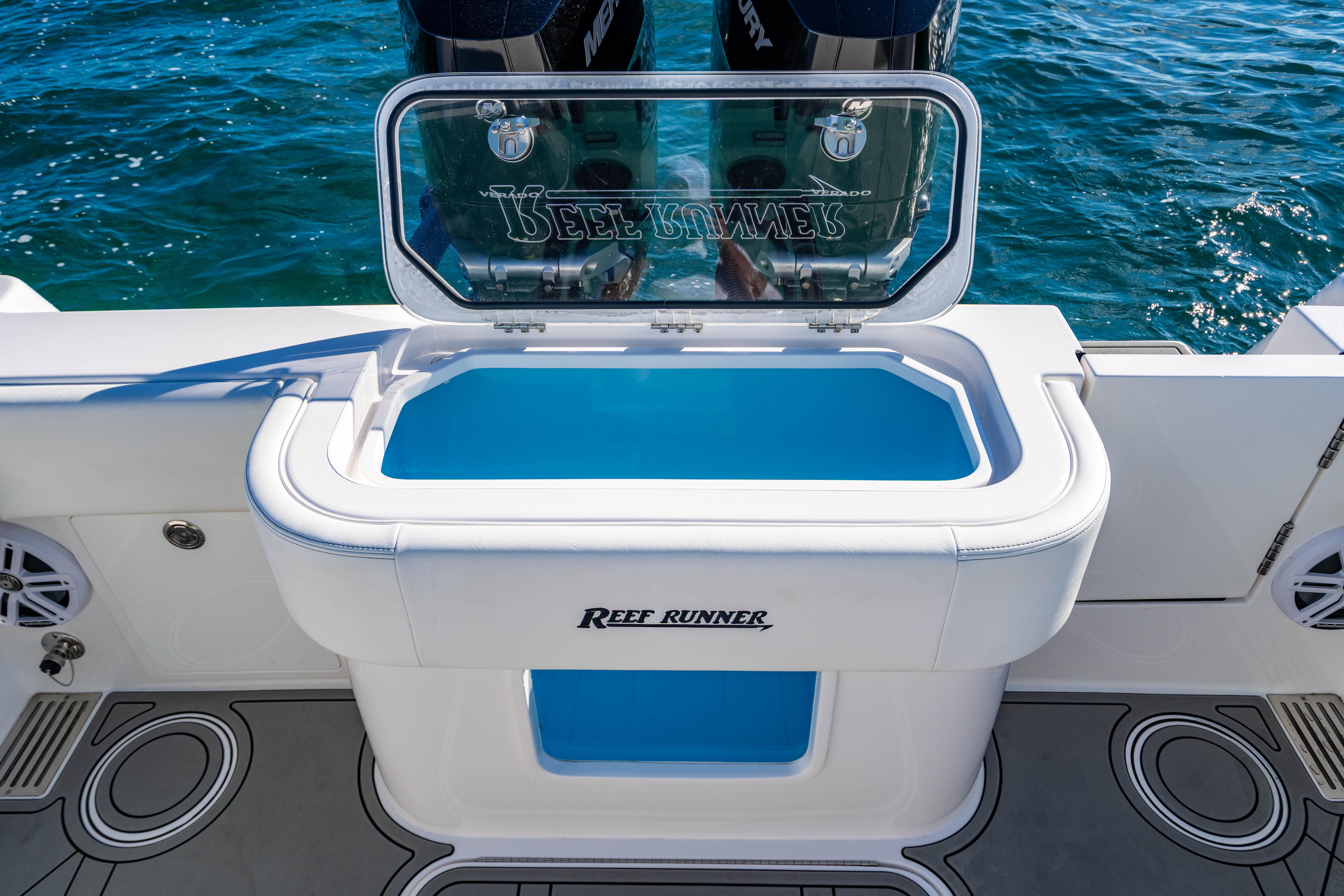 2026 Reef Runner 340 boat with open livewell, featuring sleek design and ocean backdrop.
