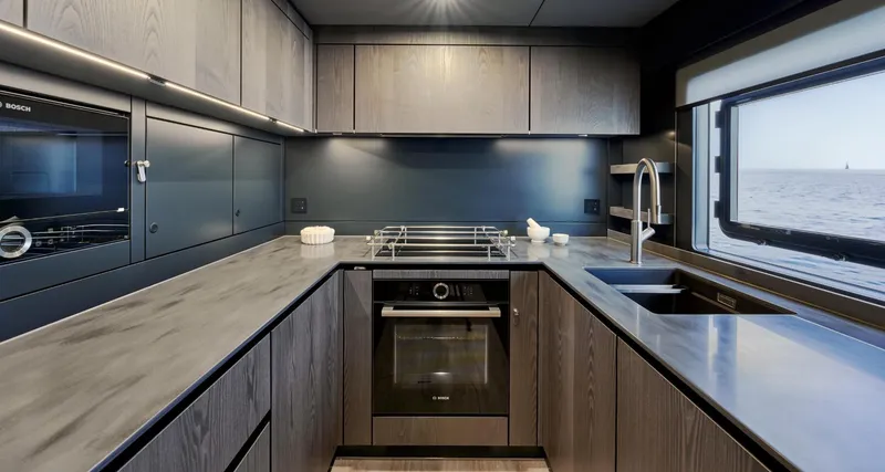  Yacht Photos Pics Modern kitchen interior on 2026 Sunreef 60 Power yacht, featuring sleek cabinetry and ocean view.